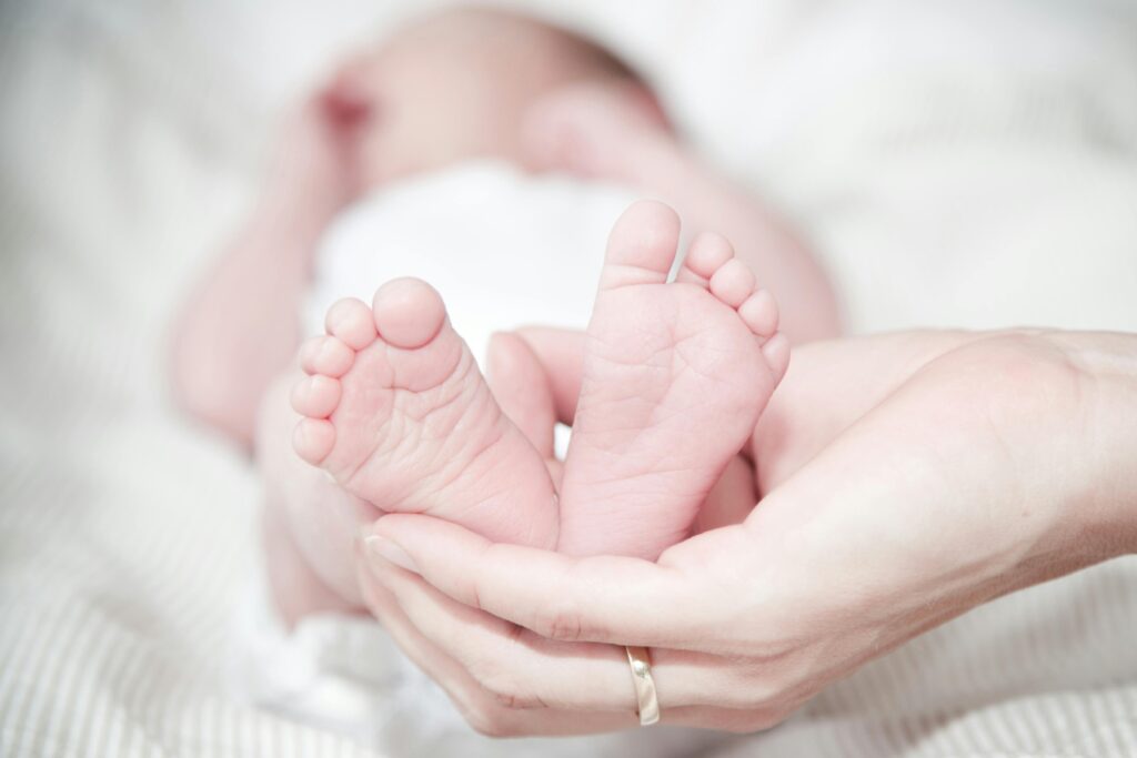 pexels photo 325690 325690 Tender photo of a mother's hands holding her newborn's feet, symbolizing love and care.